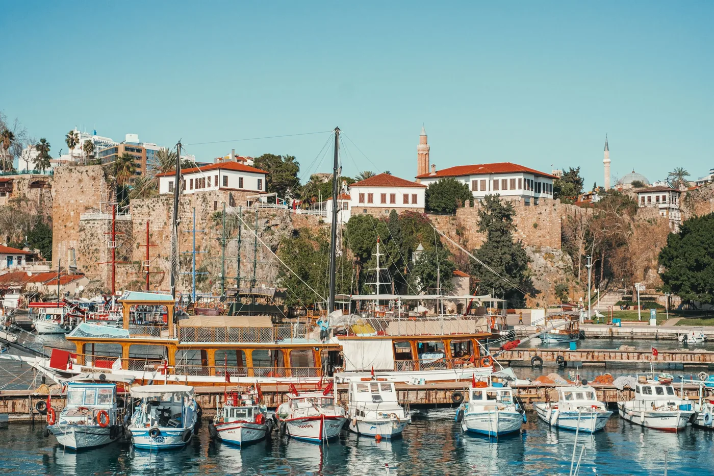 Stary port w Antalyi z łodziami rybackimi pod murami Kaleiçi
